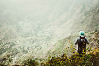 Rear view of man standing on mountain