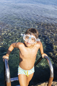 Full length of shirtless boy in sea