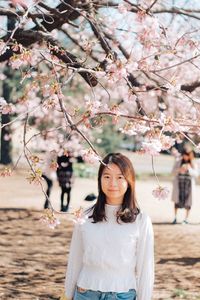 Young woman with cherry blossoms in spring
