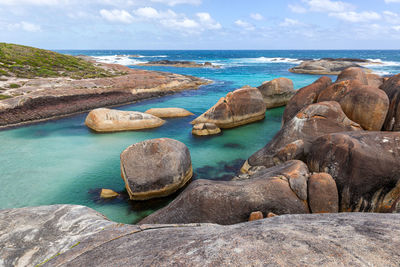 Rocks on sea shore against sky