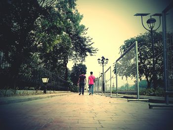 Rear view of people walking on street in city