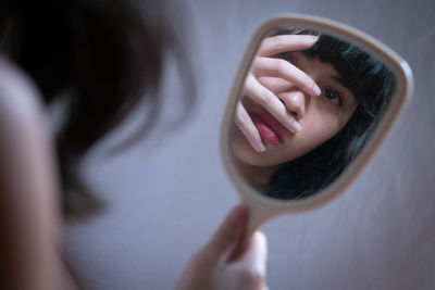 Close-up of woman reflecting on hand mirror