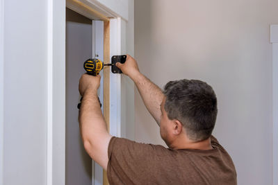 Side view of man using mobile phone at home