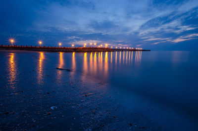 Illuminated pier at dusk