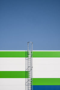 Low angle view of telephone pole against clear blue sky