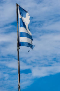 Low angle view of flag against cloudy sky