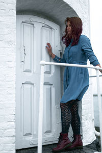 Side view of woman standing against the wall