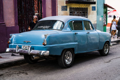 Vintage car on street against buildings in city