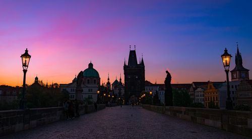 Illuminated buildings against sky at sunset