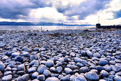 Stones on beach against sky