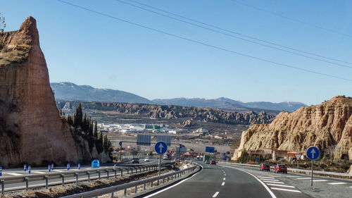 Road by mountains against clear sky