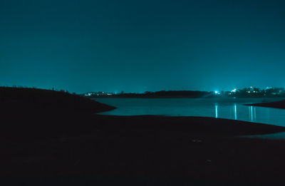 Scenic view of sea against clear blue sky at night
