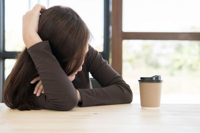 Rear view of woman sitting at table