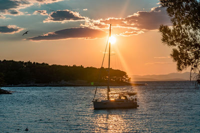 Sailboat sailing on sea against sky during sunset