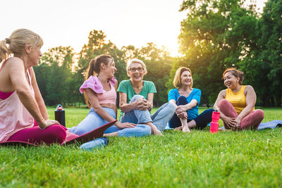 Friends sitting on grassy field