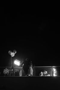 Low angle view of illuminated lights against sky at night