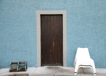 Chairs by closed door outside building