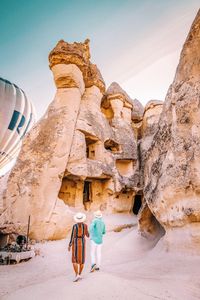 Man standing on rock against sky