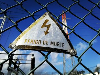 Close-up of warning sign on chainlink fence