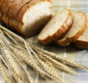 Close-up of wheat and bread on table