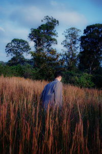 Man standing on field against sky