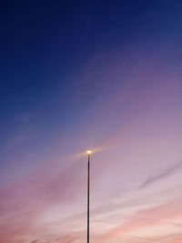 Low angle view of illuminated street light against sky at sunset