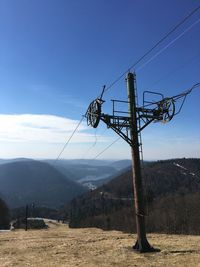 Low angle view of overhead cable car against sky