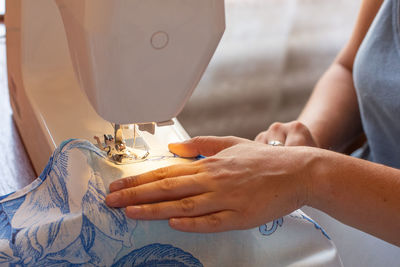 Sewing hands. female hands stitching fabric on a machine hobby at home. blurred