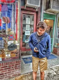 Portrait of young man standing against brick wall