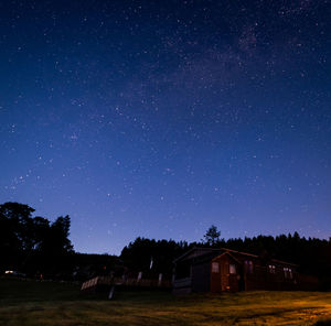 Scenic view of house and trees against sky at night