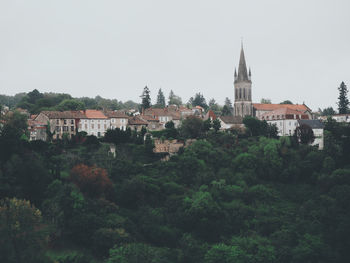 Trees and townscape against sky
