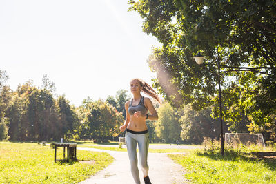 Full length of woman standing by trees against plants