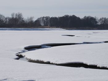 Scenic view of snow covered land against sky