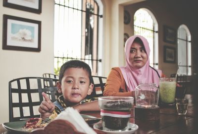 Portrait of smiling boy eating food at home