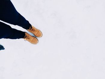 Low section of man standing on snow