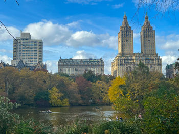Buildings by river against sky