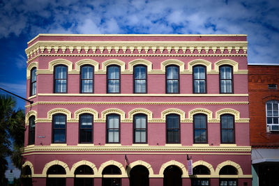 Low angle view of building against cloudy sky