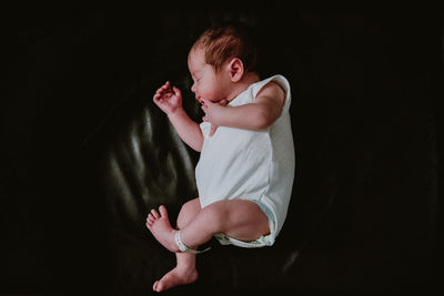 Full length of cute girl standing against black background