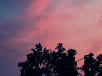 Low angle view of silhouette trees against sky at sunset