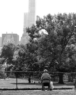 Rear view of man sitting on chair in park
