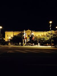 People on illuminated street at night