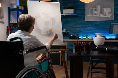 Rear view of woman sitting on table