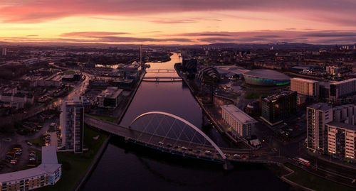 High angle view of city lit up at sunset