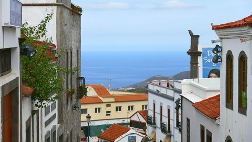 Houses by sea against sky in city