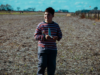 Boy with toy airplane walking on land