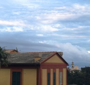 Low angle view of houses against cloudy sky
