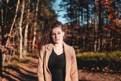 Portrait of beautiful young woman standing in forest