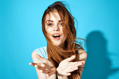 Portrait of woman against blue background