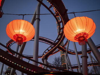 Low angle view of illuminated lanterns against sky at dusk