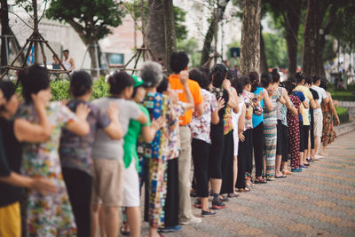 People waiting in line on footpath